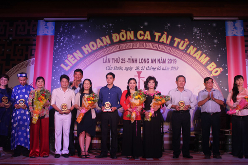 Phó Chủ tịch UBND tỉnh Long An - Phạm Văn Cảnh (thứ 5, trái qua) và nguyên Phó Bí thư Thường trực Tỉnh ủy - Đỗ Hữu Lâm (thứ 2, phải qua) tặng hoa cho các Ban Đờn ca tài tử tham gia liên hoan